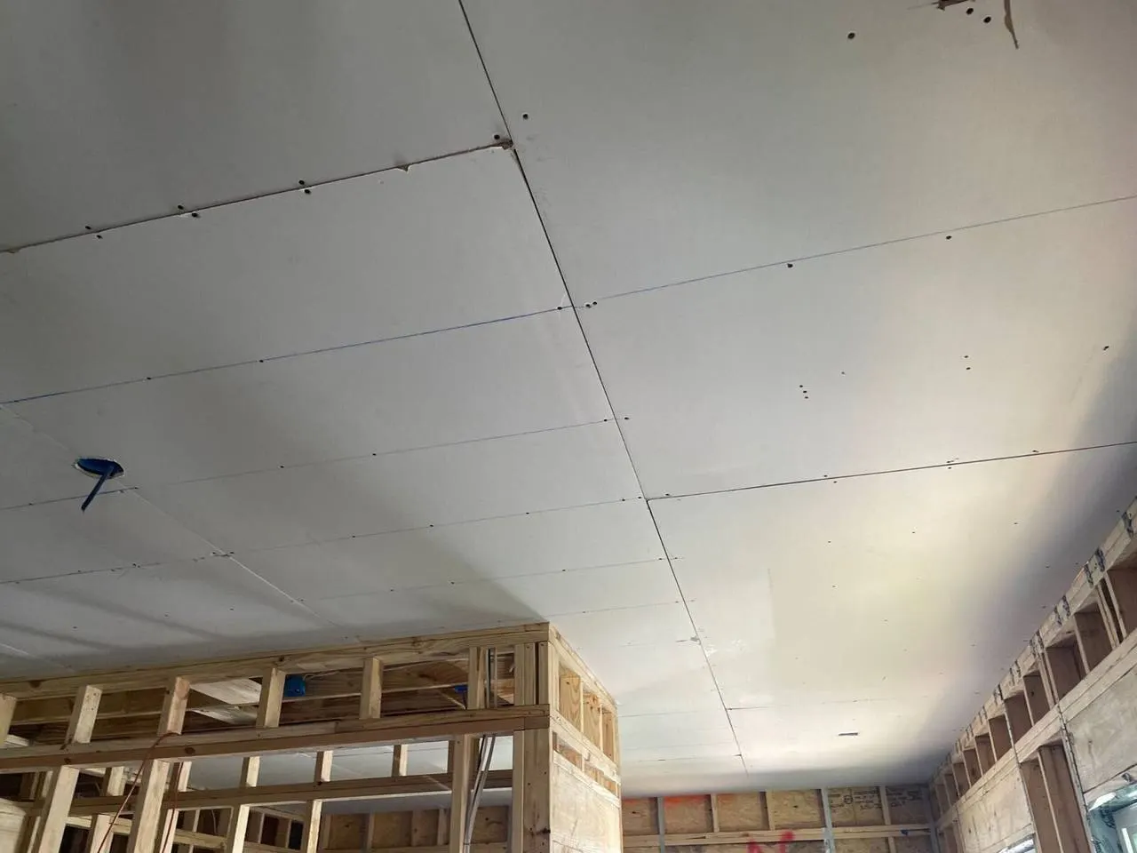 New drywall ceiling installation over wood framing during Gretna home construction project