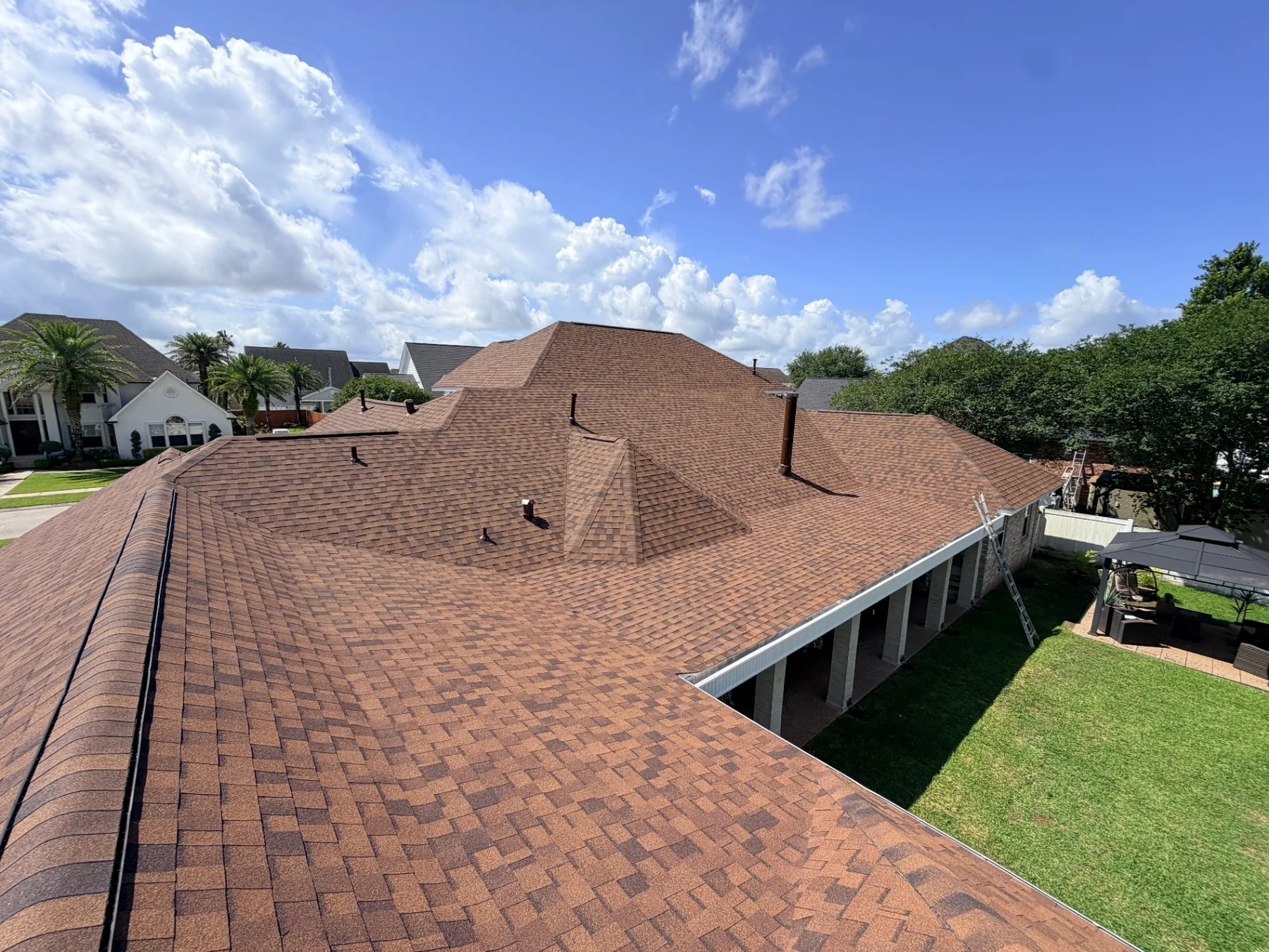 Drone view of the completed Atlas Pinnacle Pristine architectural shingle roof on a Destrehan Louisiana home showing crisp hip lines, ridge vents, and uniform shingle courses after full re-roof by Cajun Home Services