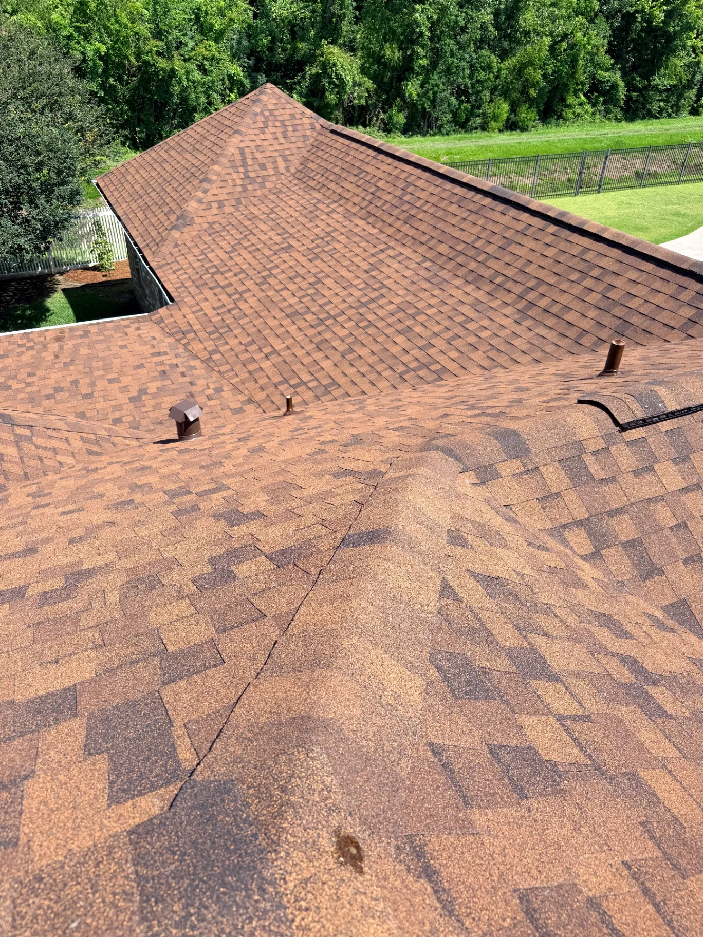 Aerial close view of the finished Atlas Pinnacle Pristine architectural shingle roof on the Destrehan Louisiana home showing new ridge vents, plumbing boot flashings, and clean valley lines installed by Cajun Home Services