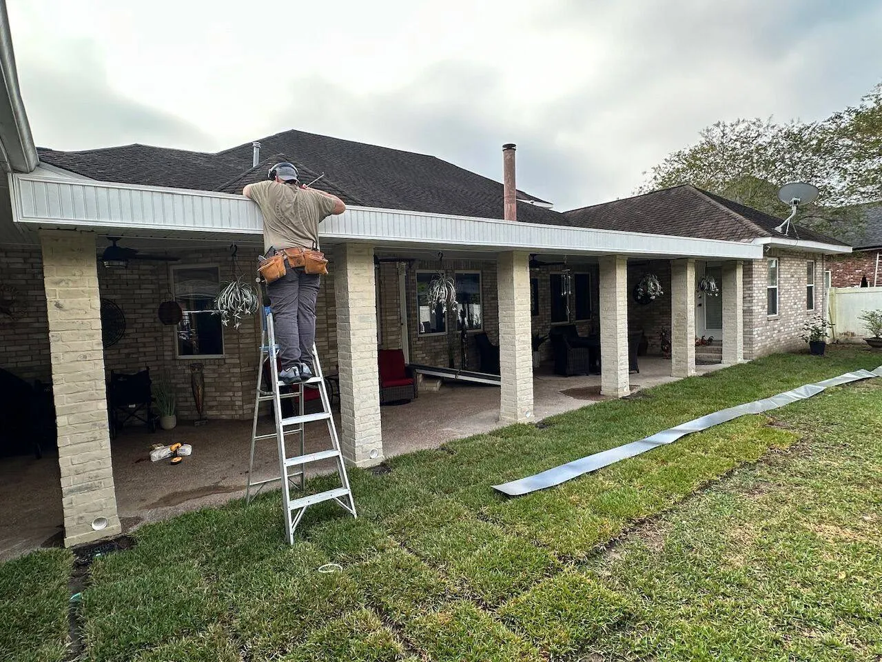 Crew installing gutter and fascia on covered patio in Metairie Louisiana
