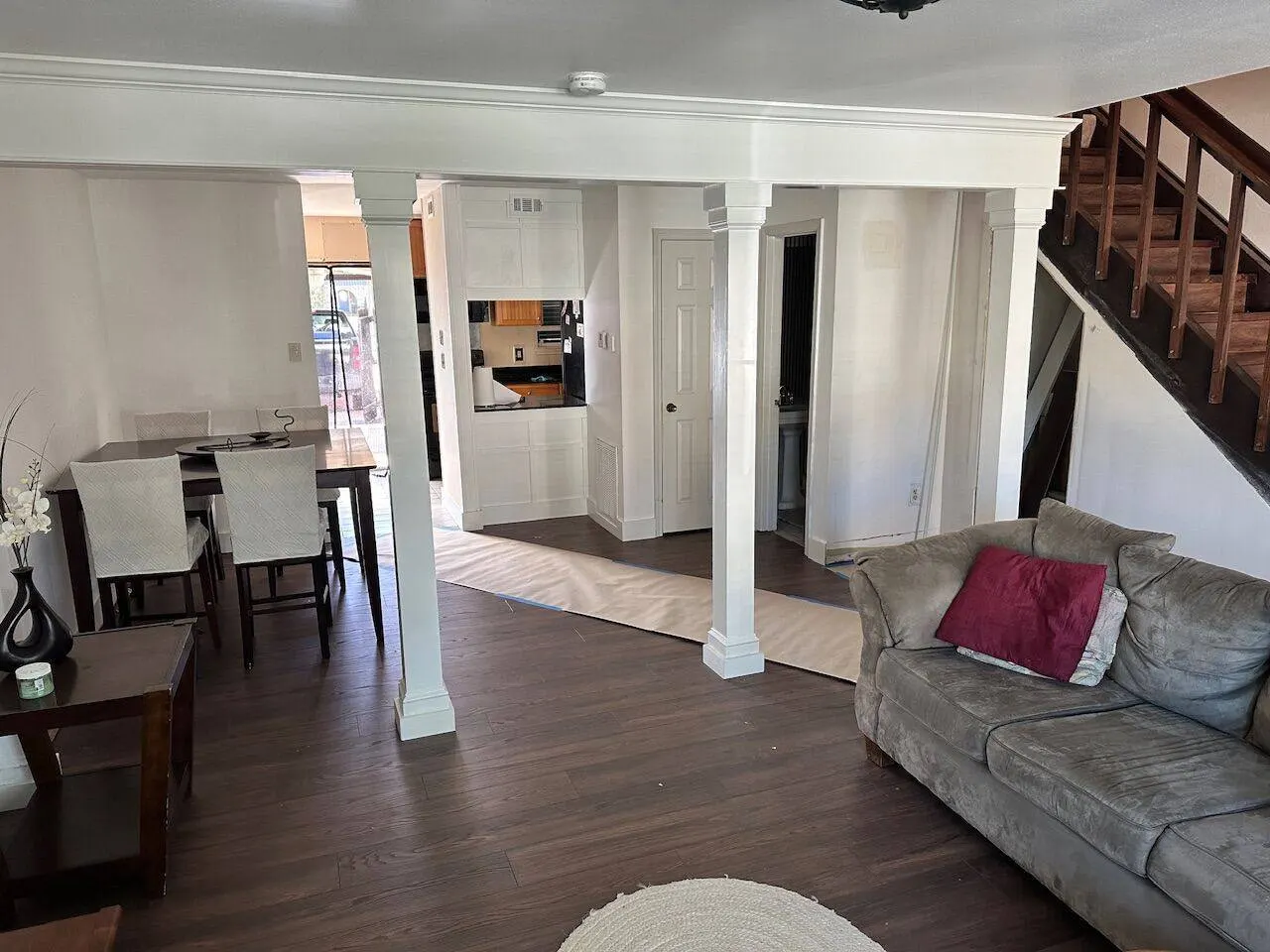 Completed living room renovation with decorative columns and dark hardwood floors in Metairie LA