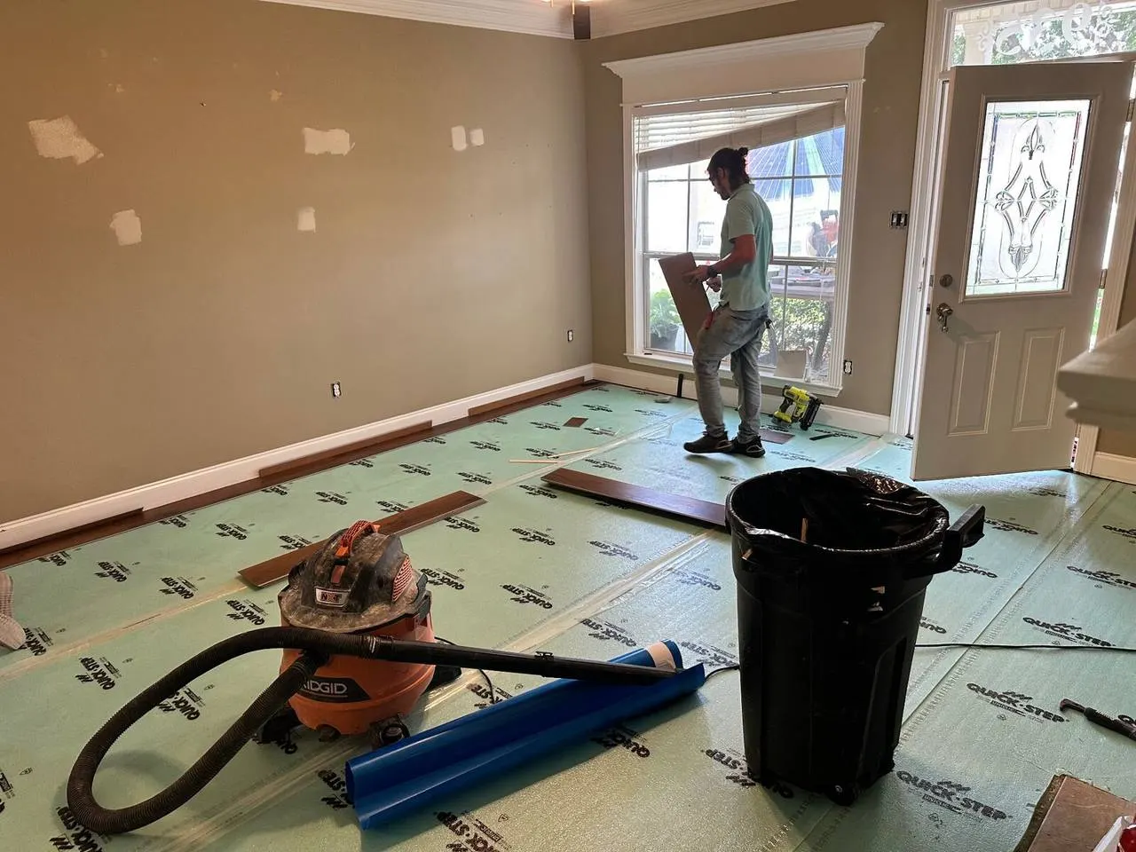 Crew installing LVP flooring with underlayment in Gonzales