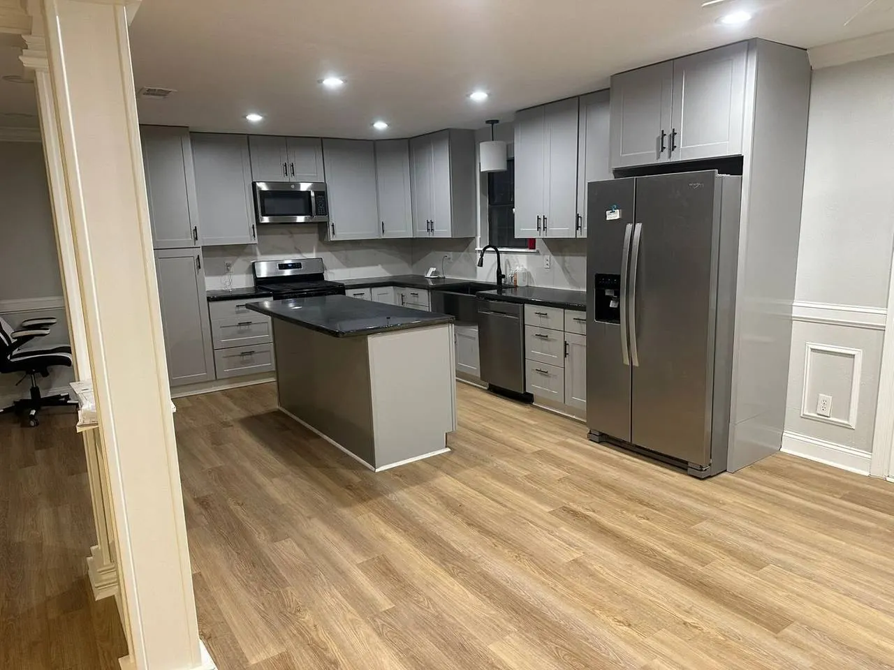 Modern kitchen remodel with large island and white cabinetry in Metairie Louisiana home