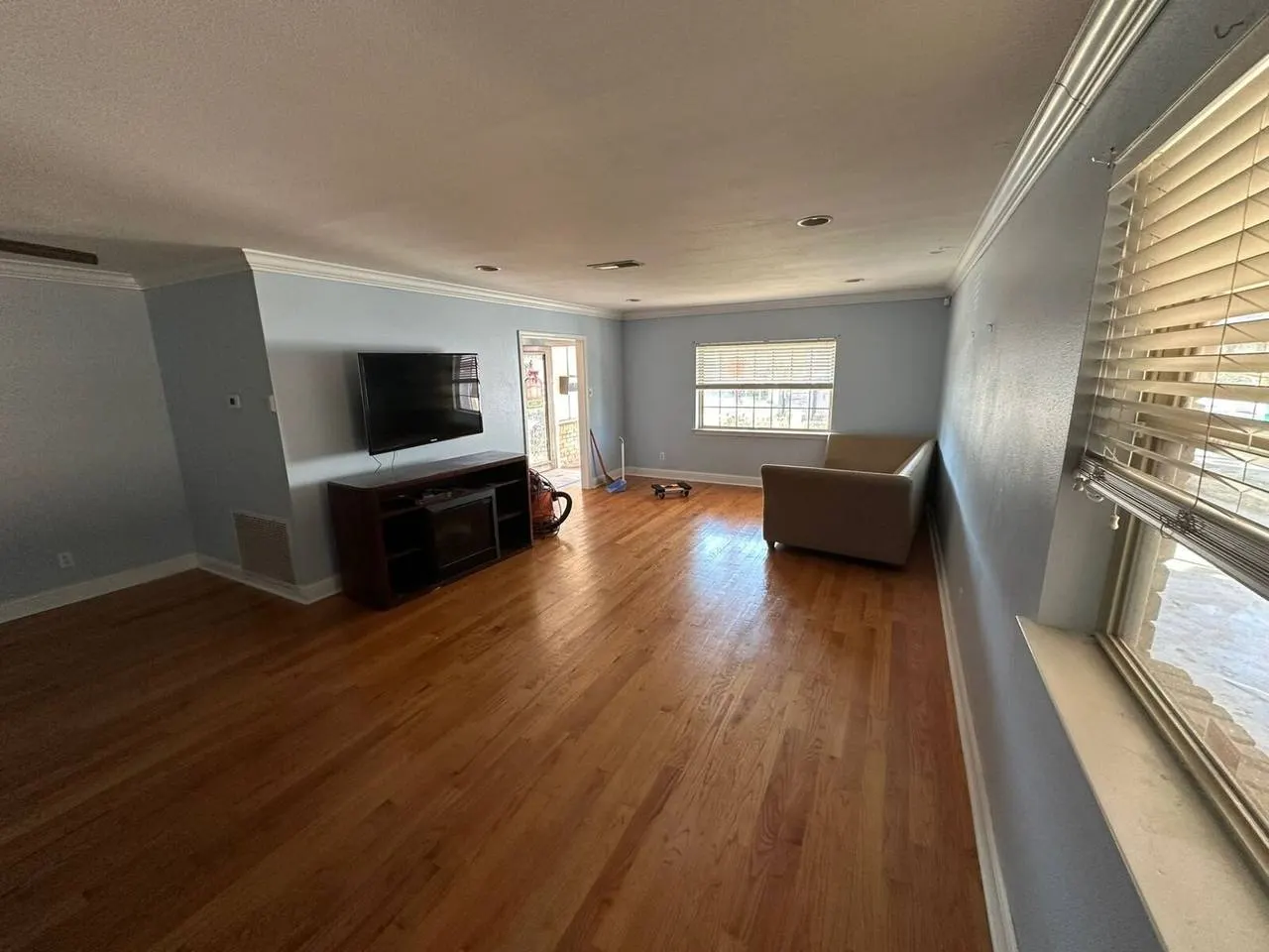 Open living room renovation with refinished hardwood floors in Covington LA
