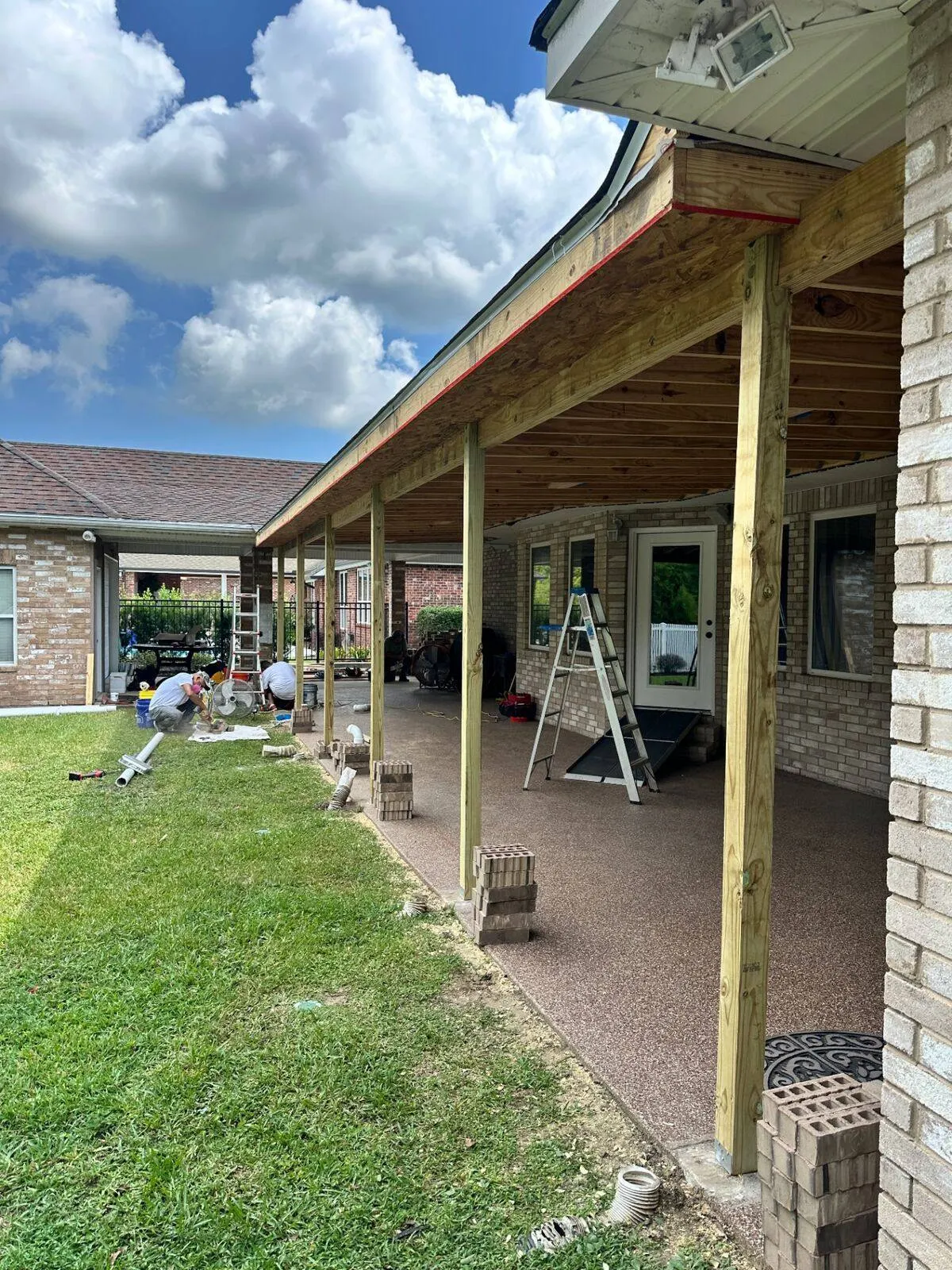 Patio posts and roof framing with crew working in Destrehan residential project
