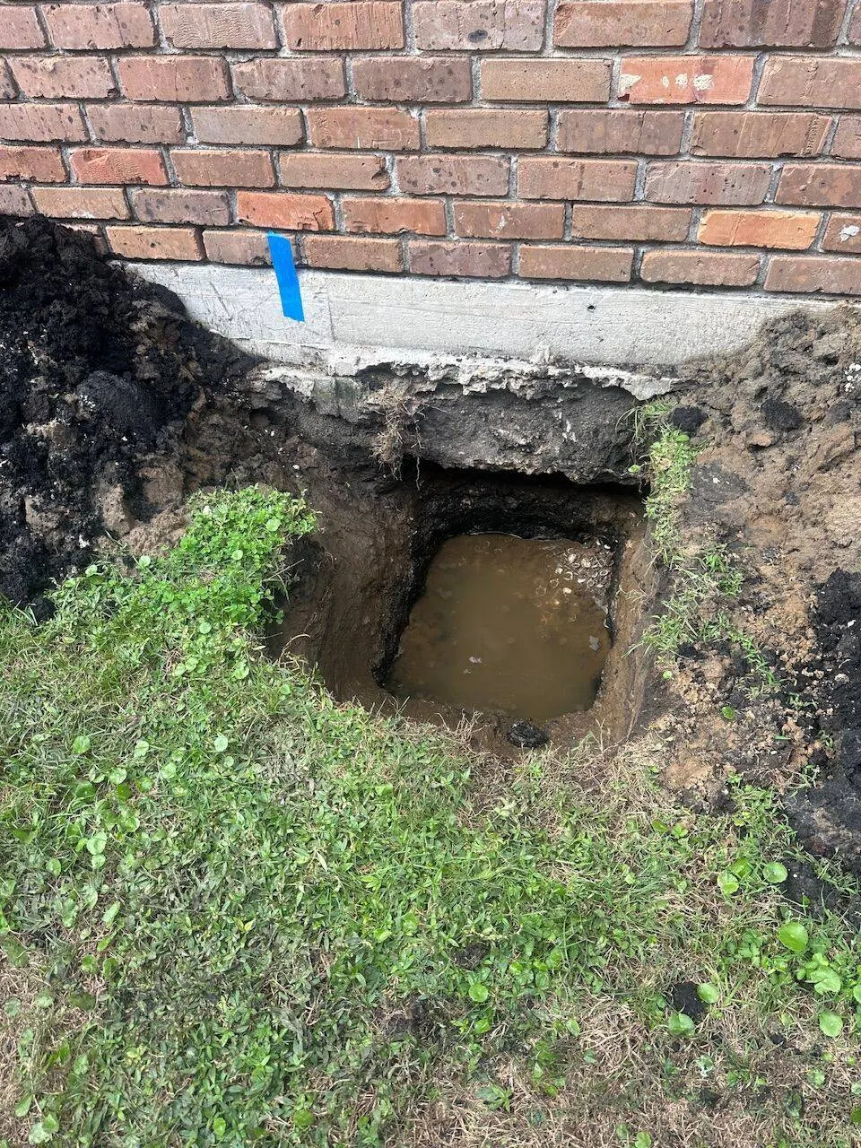 Foundation pier excavation revealing water intrusion problem in Metairie Louisiana slab foundation
