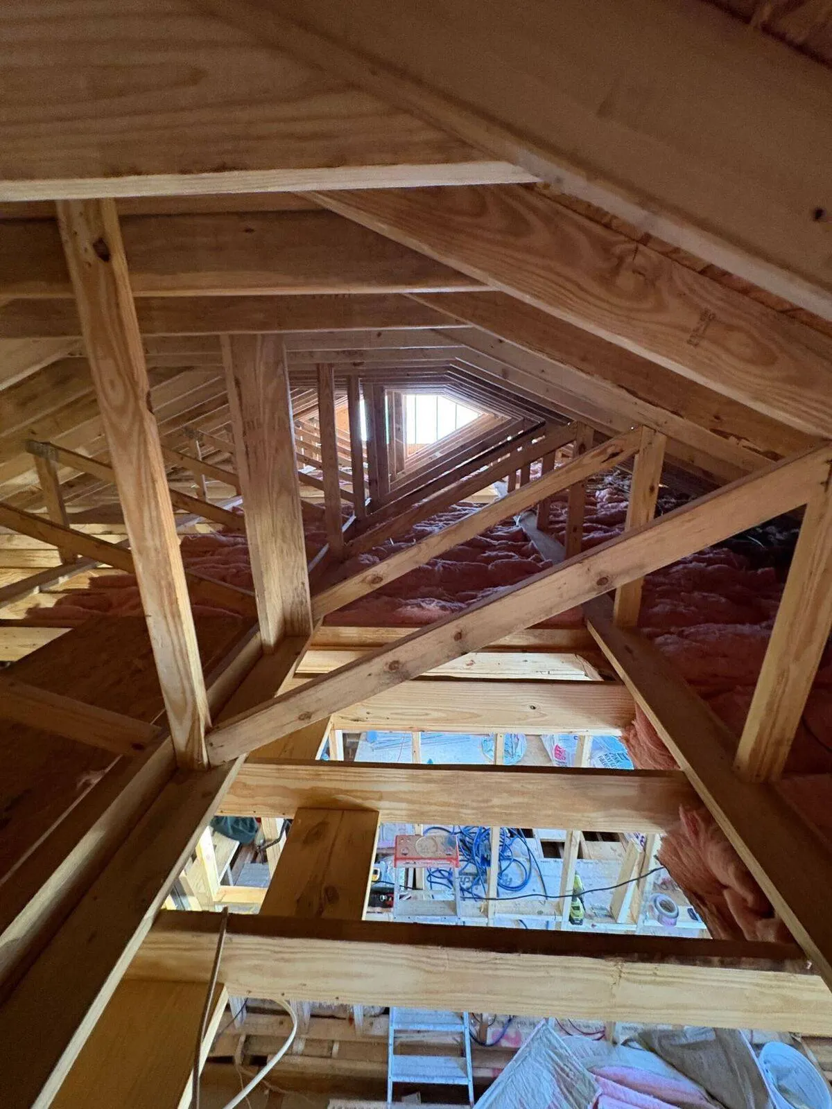 Roof truss framing interior view with insulation during new construction in Kenner Louisiana