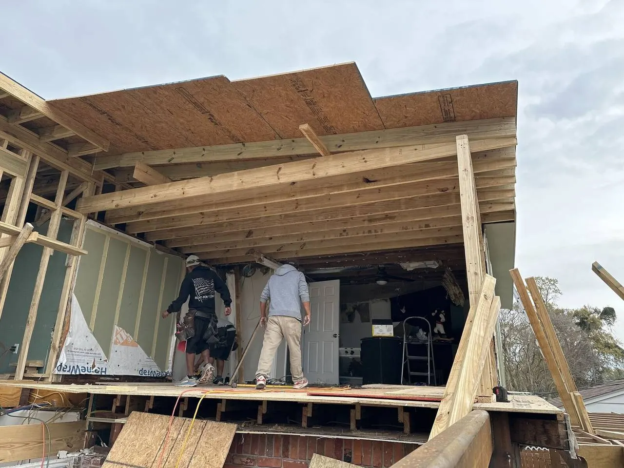 Professional roofing crew rebuilding roof structure after hurricane damage in New Orleans