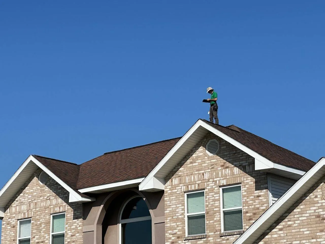 Roofing crew member inspecting completed roof installation in Louisiana