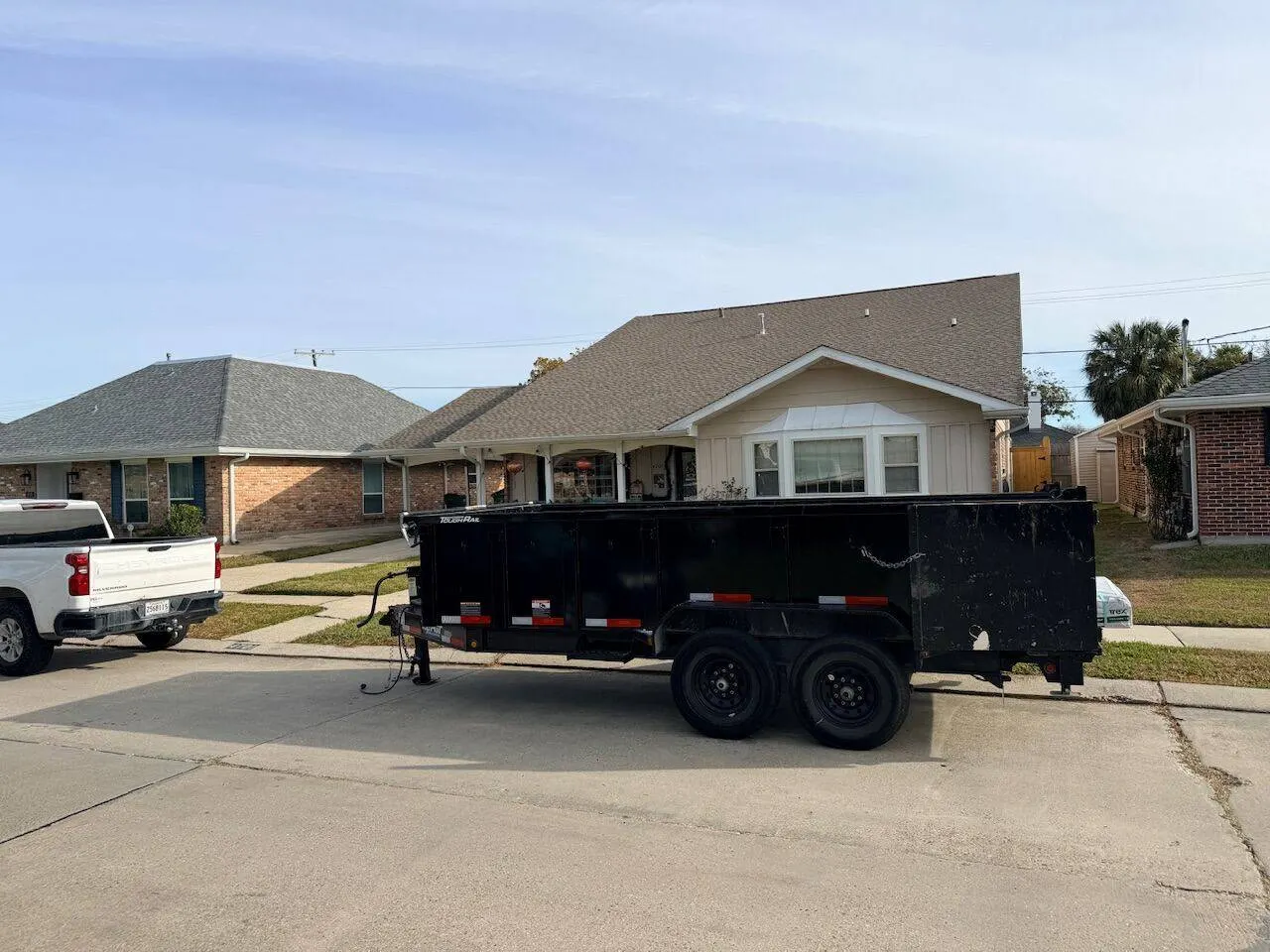 Roof replacement project with dump trailer on site in Louisiana