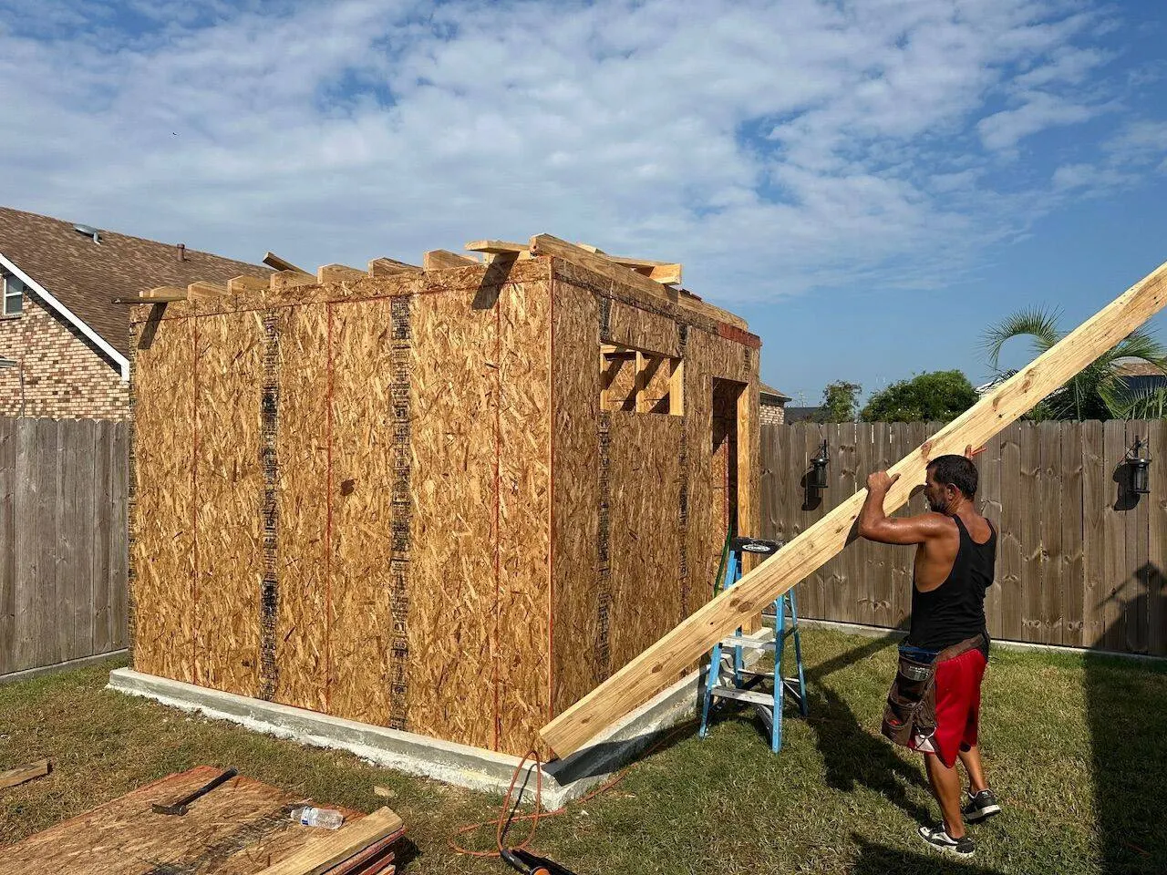 Crew member installing rafter on new construction shed in Meraux Louisiana