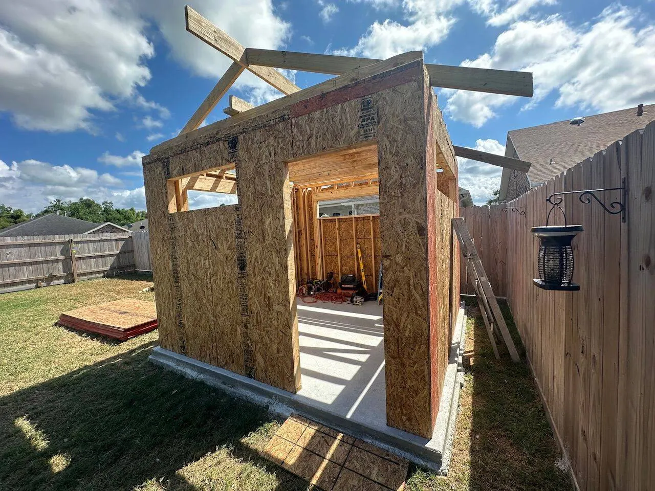 New construction shed with OSB sheathing and concrete slab in Meraux LA backyard