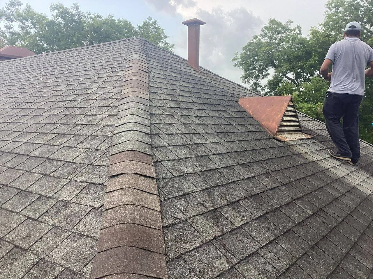 Architectural shingle roof with ridge detail and vent flashing during final punch work
