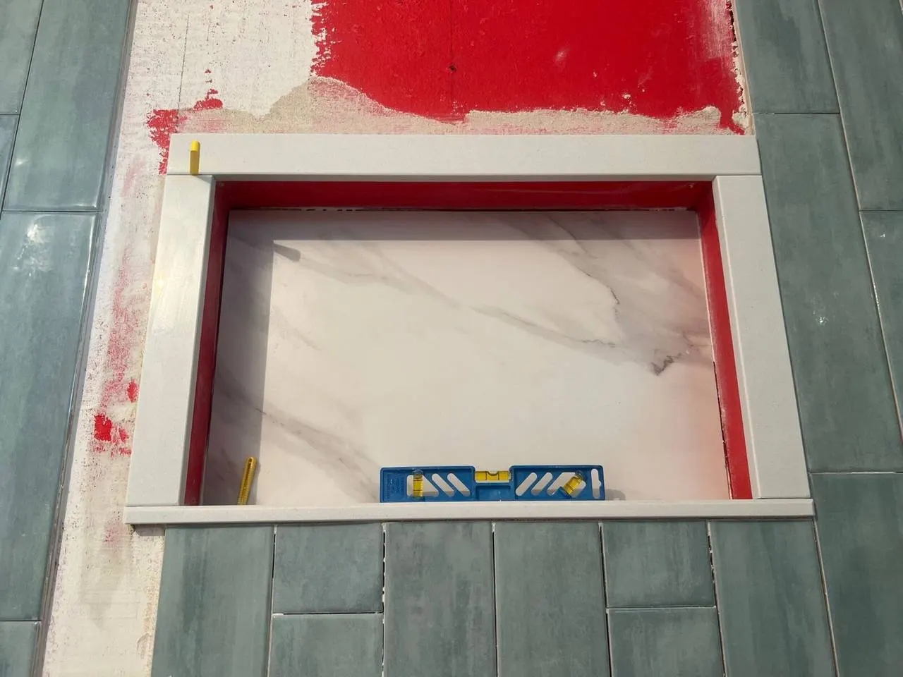 Custom shower niche with marble and green tile during bathroom remodel in Metairie Louisiana