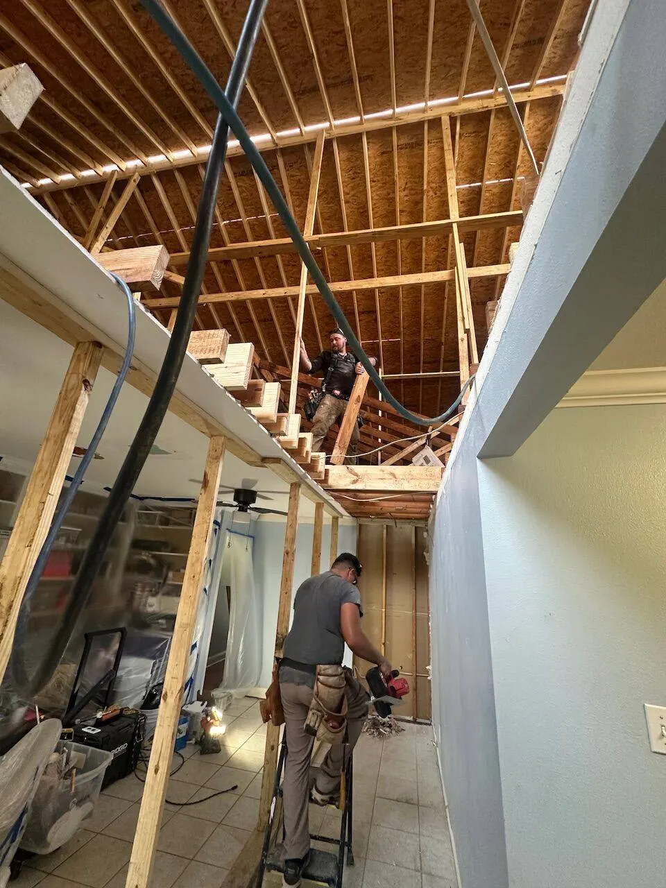 Crew framing grand stairwell for second floor master bedroom addition in Metairie