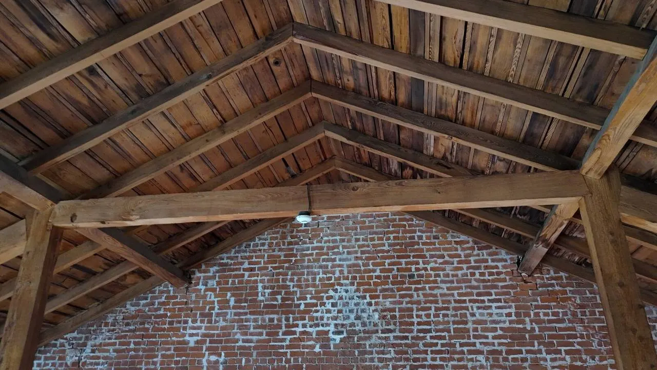 Exposed wood rafters and brick wall restoration in historic Vieux Carré building interior