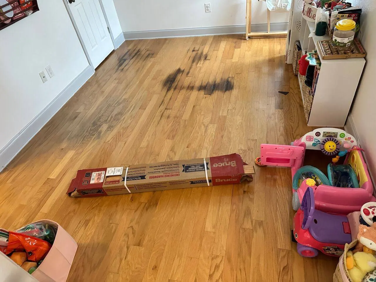 Water-damaged hardwood flooring with dark staining requiring structural repair and replacement