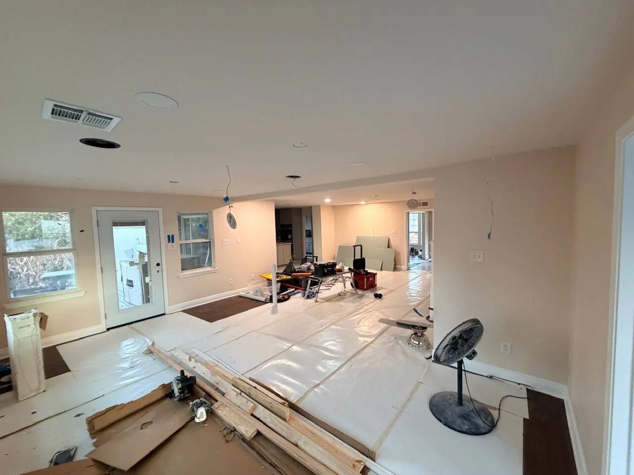 Open floor plan renovation with construction materials during whole home remodel in Metairie