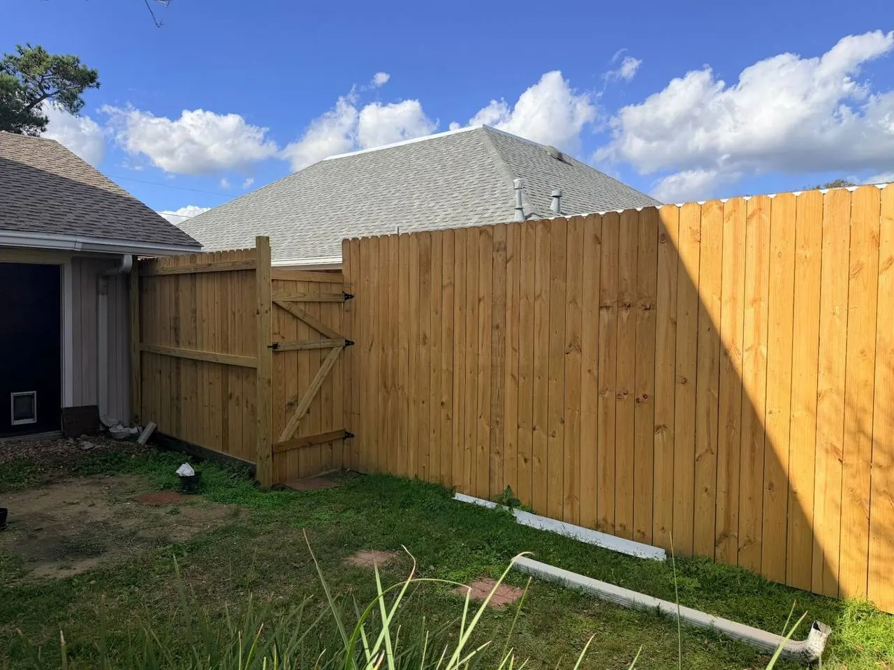 New wood privacy fence with gate installed in Metairie backyard